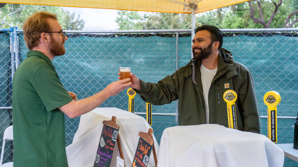 Innovation Brew Works employee handing a guest a beer sample